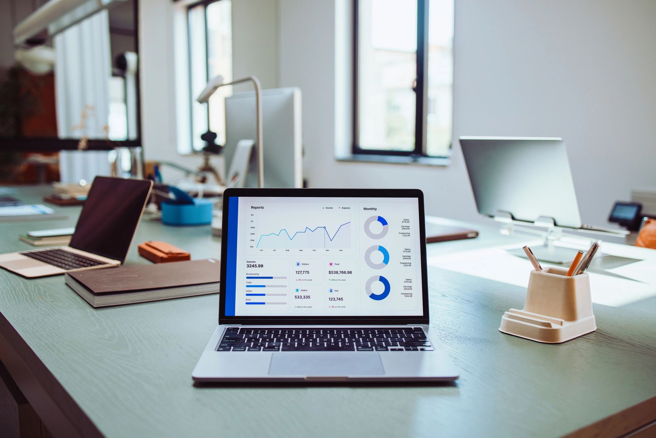 Modern office workspace with laptops showing business analytics